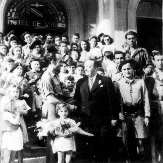Jean DEFFAUGT, sur le parvis de l'hôtel de ville d'Annemasse libérée, entouré des enfants juifs qu'il a sauvés